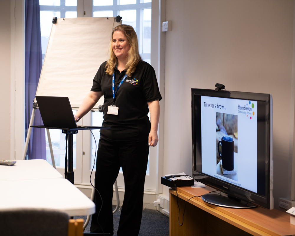 Woman standing next to screen and presenting a slide